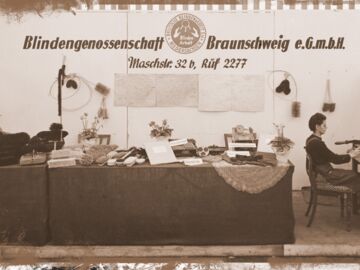 Ausstellung von Blindenwaren in der Blindengenossenschaft Braunschweig e.G.m.H. und eine blinde Handwerkerin beim Bürsteneinziehen
