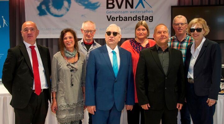 Die acht Personen stehen in der angegeben Reihung vor dem Banner des Verbandstags: BVN – Gemeinsam Weitersehen